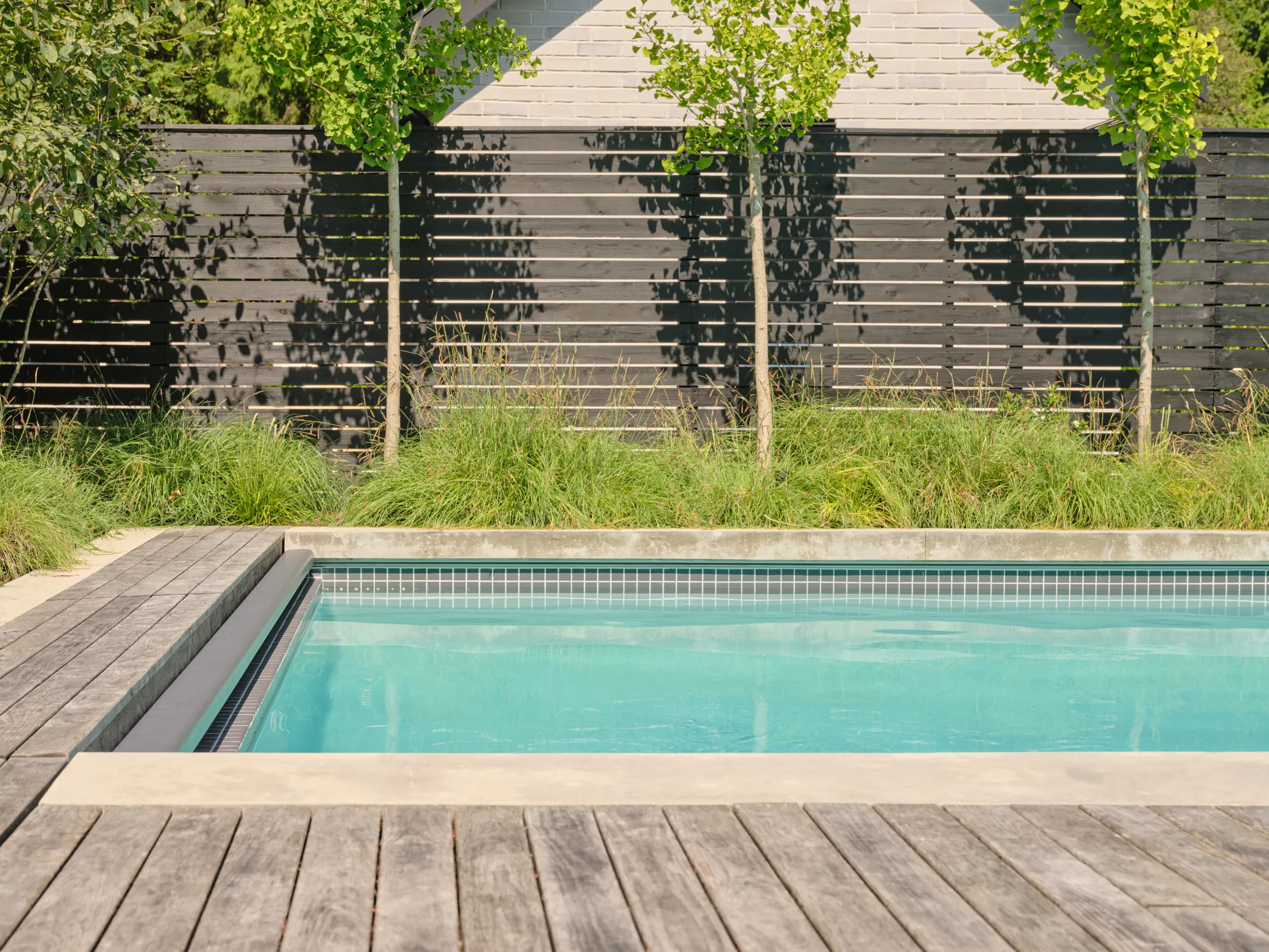 Poolside view of the minimalist concrete pool house, Capilano